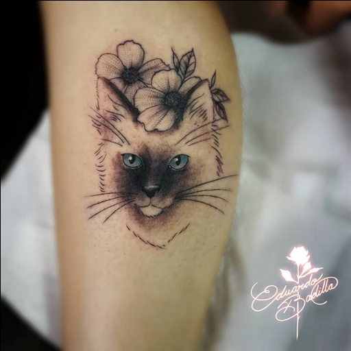 imágen de tatuaje de un gato con flores de fondo hecho a blanco y negro con ciertos detalles a color